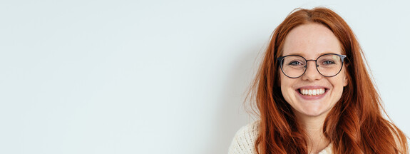 Frau mit Brille, die lacht.