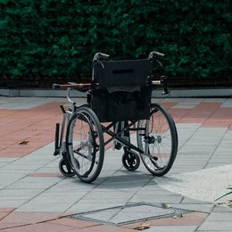 Ein Rollstuhl steht verlassen auf einem Platz.