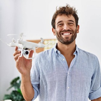 Ein Mann hält eine Drohne in der Hand.